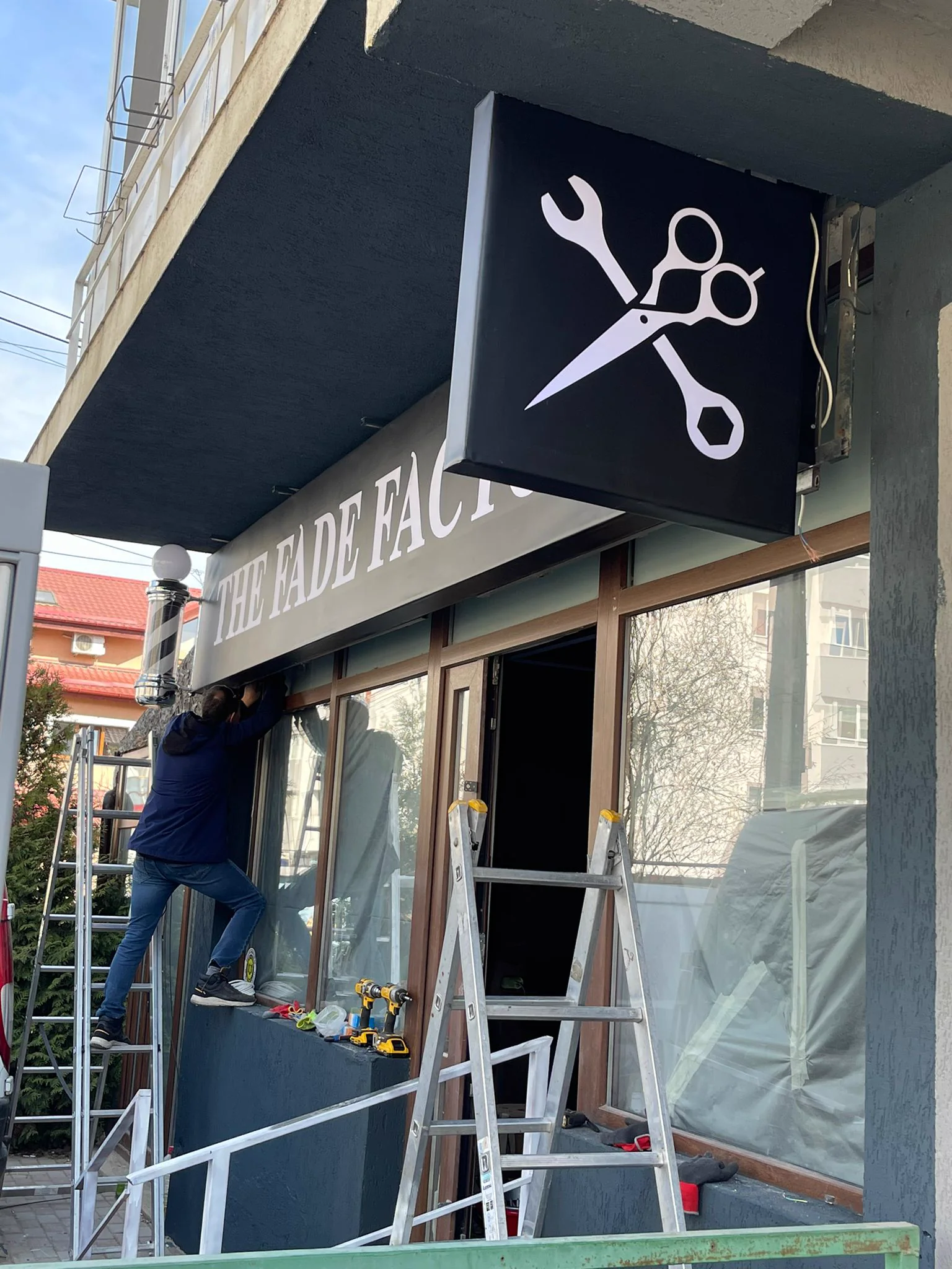 The Fade Factory — firmă luminoasă montată la frizerie